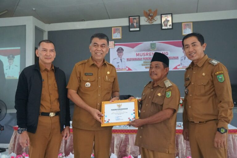 Wakil Bupati Natuna saat menyerahkan penghargaan Desa bebas stunting di Desa Subi, Natuna, Kepri. Sumber foto: Istimewa.