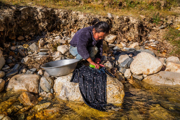 Ilustrasi warga cuci baju di sungai. Sumber foto: iStock.