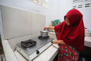 Warga Desa Rajek, Siti Aminingsih memanfaatkan gas rawa untuk memasak. Sumber foto: Istimewa.