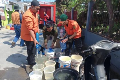 Petugas BPBD saat mendistribusikan air bersih kepada warga. Sumber: Humas BPBD Kabupaten Bandung.