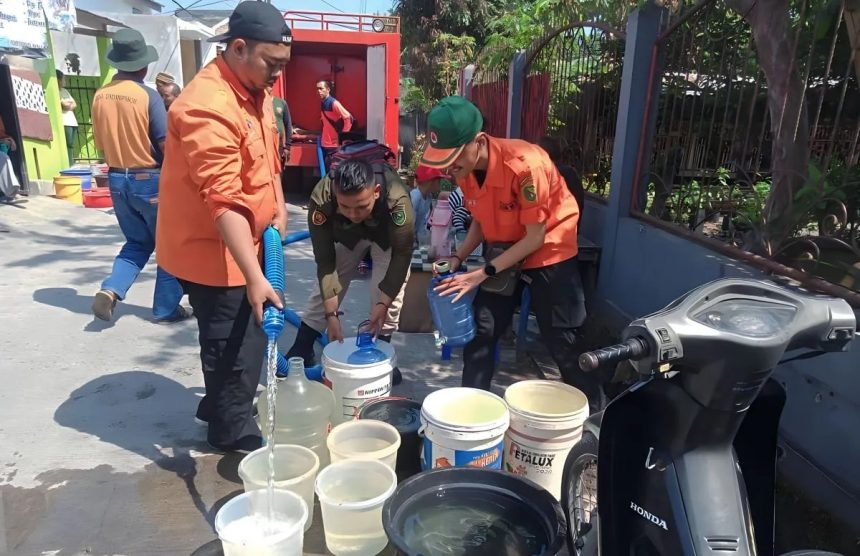 Petugas BPBD saat mendistribusikan air bersih kepada warga. Sumber: Humas BPBD Kabupaten Bandung.