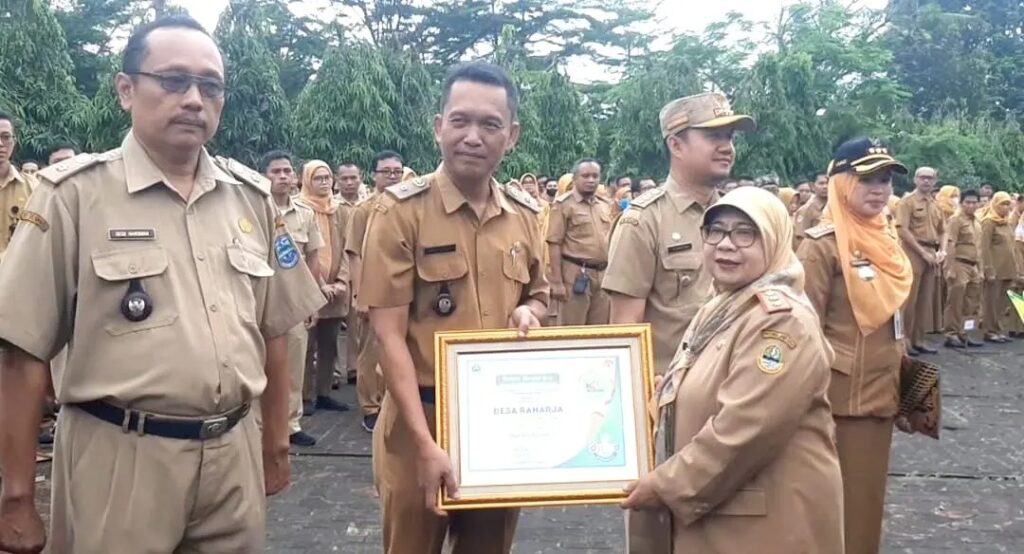 Pj Walikota Banjar, Ida Wahida Hidayati saat menyerahkan piagam penghargaan kepada Desa Raharja. Sumber foto: Dok Pemkot Banjar.