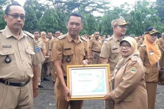Pj Walikota Banjar, Ida Wahida Hidayati saat menyerahkan piagam penghargaan kepada Desa Raharja. Sumber foto: Dok Pemkot Banjar.