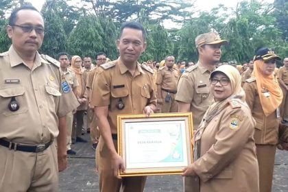 Pj Walikota Banjar, Ida Wahida Hidayati saat menyerahkan piagam penghargaan kepada Desa Raharja. Sumber foto: Dok Pemkot Banjar.