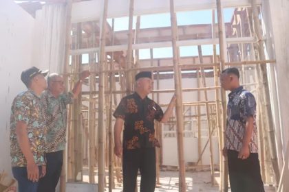 Kades Gumulan Busroni (tengah) bersama perangkat desa meninjau progres pembangunan ruangan baru untuk kantor desa Gumulan. Foto : Achmad RW/Radar Jombang