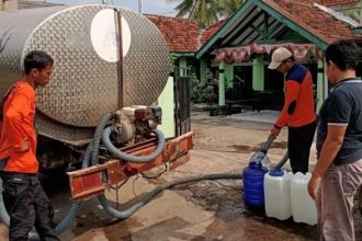 Petugas mendistribusikan air bersih pada warga Dusun Krajan, Desa Wangkal, Kecamatan Gading. Foto : wartabromo.com