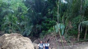 Siswa saat melewati jalan akibat banjir bandang di Desa Gegelang. Sumber foto : Tribunbali