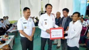 Penjabat Bupati OKI saat membagikan bantuan senilai Rp 10 juta untuk perbaikan rumah tidak layak huni. Sumber foto: keizalinnews.com