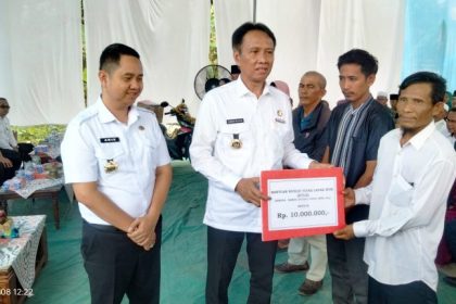 Penjabat Bupati OKI saat membagikan bantuan senilai Rp 10 juta untuk perbaikan rumah tidak layak huni. Sumber foto: keizalinnews.com