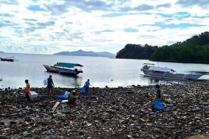 keterangan foto: warga memungut sampah di pantai, sumber foto: Antara