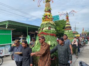 Warga Desa Dempet, Kecamatan Dempet, Kabupaten Demak, sedang mengarak gunungan dalam kirab Apitan atau sedekah bumi. Sumber : dinkominfo.demakkab.go.id