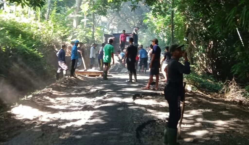 Warga Desa Tigawasa gotong royong melakukan perbaikan jalan secara swadaya. Sumber : Radarbali