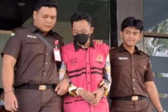 Mantan Kades Maskuning Kulon berinisial UR mengenakan rompi merah jambu digiring penyidik Kejaksaan menuju Lapas Bondowoso.