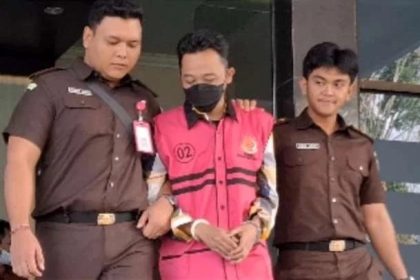Mantan Kades Maskuning Kulon berinisial UR mengenakan rompi merah jambu digiring penyidik Kejaksaan menuju Lapas Bondowoso.