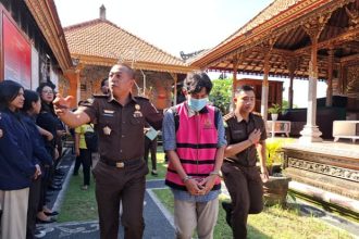 Tersangka korupsi APBDes Desa Tusan, Kecamatan Banjarangkan, Kabupaten Klungkung I Gede KS digiring oleh aparat Kejari Klungkung. Sumber foto : wartabali