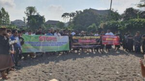 Sejumlah Krama Desa Adat bersama Bendesa Adat dan tokoh masyarakat lainnya saat melakukan penolakan dengan membentangkan Baliho di Pantai Lima. Sumber: Tribunbali