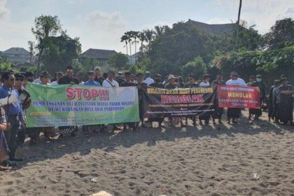 Sejumlah Krama Desa Adat bersama Bendesa Adat dan tokoh masyarakat lainnya saat melakukan penolakan dengan membentangkan Baliho di Pantai Lima. Sumber: Tribunbali