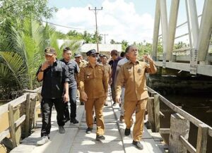 Pj Bupati Inhil H Herman saat meninjau kondisi Jembatan, Desa Pulau Kecil, Kecamatan Pulau Reteh. Sumber Foto: Dok. Riaupos.com