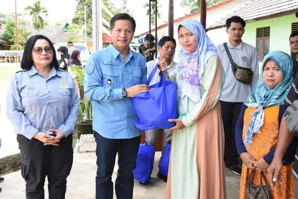 Pj Bupati Barito Utara Muhlis didampingi Kepala Perdagangan dan Perindustrian Dewi Handayani menyerahkan paket sembako murah secara simbolis untuk masyarakat di Desa Sikui.