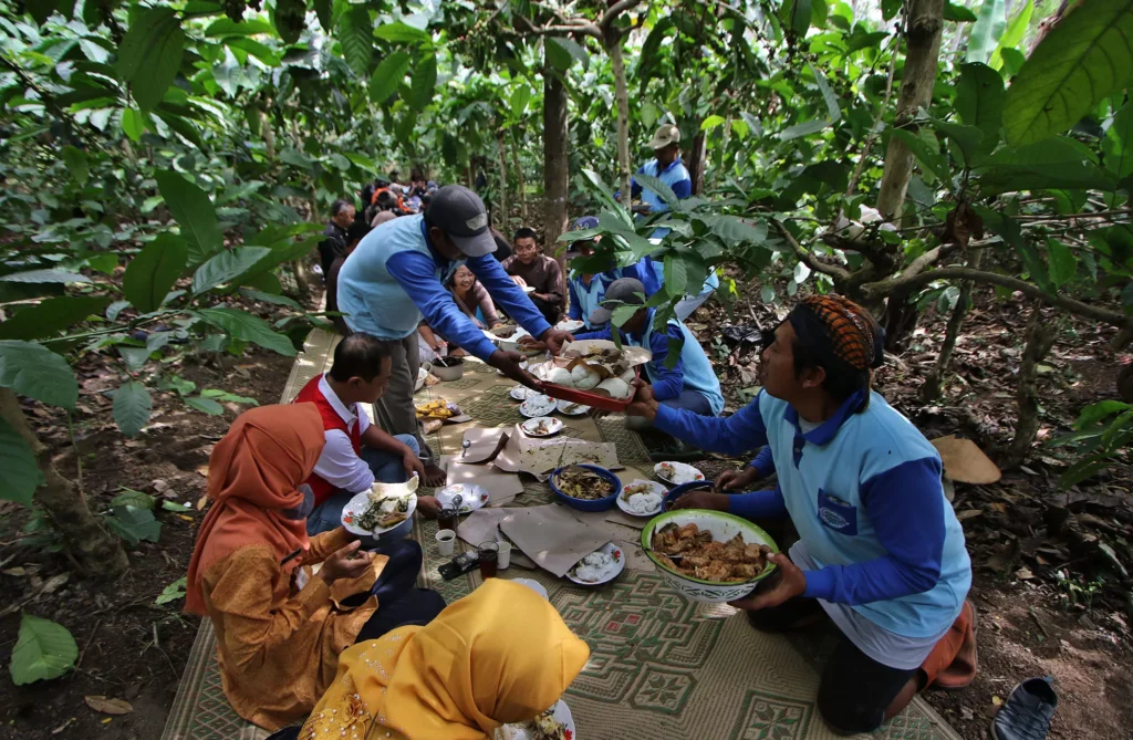 Masyarakat Banyuanyar sedang melaksanakan kegiatan Wiwit Kopi di tengah kebun. Sumber: Radar Solo