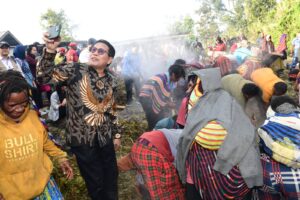 Menteri Desa, Pembangunan Daerah Tertinggal, dan Transmigrasi Abdul Halim Iskandar mengikuti ritual bakar batu bersama warga Distrik Walesi, Papua Pegunungan, Rabu (17/7/2024). Sumber: Kolomdesa