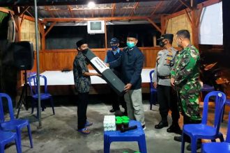 Warga yang bertugas ronda sedang mengumpulkan uang jimpitan dari salah satu rumah warga RT 12 Desa Gunung Makmur Kecamatan Antang.