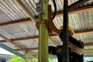 Petugas PLN sedang melakukan aktivasi pada kWh Prabayar di salah satu rumah warga Desa Beluh Mulyo.