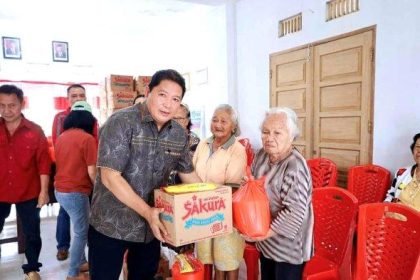 Pj Bupati Minahasa saat memberikan bantuan kepada warga terdampak banjir. Sumber Foto: Istimewa