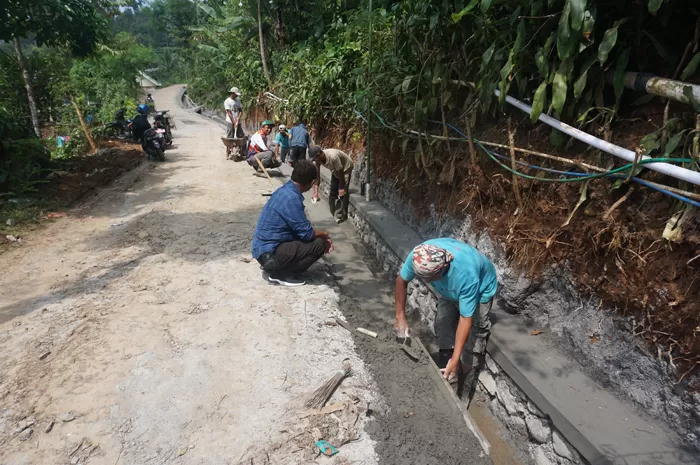 Kepala Desa Galengdowo Wartomo (kemeja biru) menunjukkan lokasi pembangunan drainase di Dusun Galengdowo yang sedang dikerjakan oleh TPK Desa Galengdowo. Sumber : Dwi Aris S/Radar Jombang