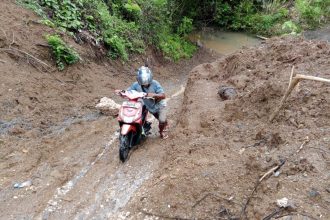 Warga Desa Morodadi saat melalui jalan berlumpur karena tidak ada jembatan alternatif. Sumber: Dok. Suara Ternate