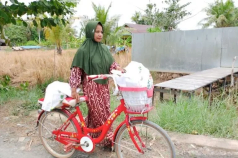 Salah satu warga membawa bantuan kebutuhan pokok.