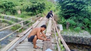 Warga memperbaiki secara mandiri jembatan yang mengalami ke rusakan di Desa Tumingki, Kecamatan Loksado, Kabupaten Hulu Sungai Selatan, Kalsel.