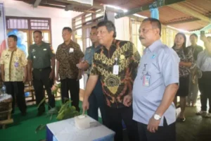 Pj Bupati Kepulauan Sangihe, Albert Huppy Wounde menekan bel tanda pemberian penghargaan Kampung Lelipang menjadi Desa Bersinar. Sumber : cahayasiang.id