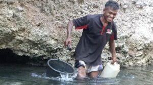 Warga Dusun Wairbura, sedang ambil air di dinding bukit tempat keluarnya bersih. Sumber foto : Pos-Kupang