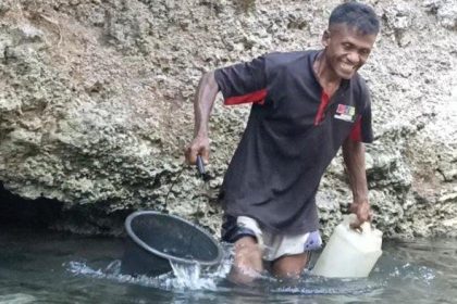 Warga Dusun Wairbura, sedang ambil air di dinding bukit tempat keluarnya bersih. Sumber foto : Pos-Kupang