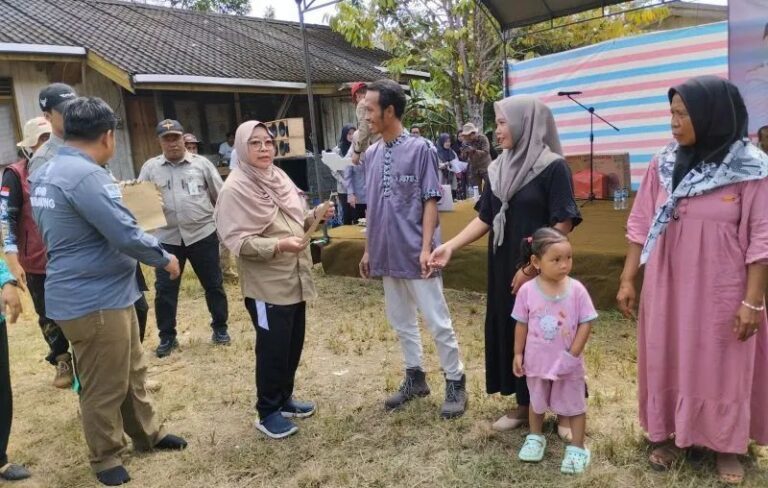 Penjabat Bupati Tabalong Hamida Munawarah menyerahkan bantuan kepada warga Desa Sungai Kumap Kecamatan Muara Uya.