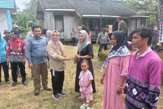 Pj Bupati Tabalong, Hj Hamida Munawarah menyerahkan hasil layanan pembuatan dokumen kependudukan untuk warga Desa Salikung dan Sungai Kumap.