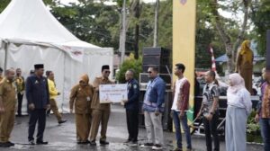 Penyerahan hadiah oleh Paman Birin Gubernur Kalimantan Selatan, Kepada Perwakilan BUMDes Sumber Rezeki, Desa Sungai Cuka Kecamatan Satui.