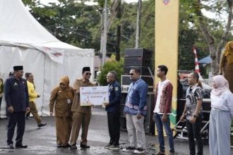 Penyerahan hadiah oleh Paman Birin Gubernur Kalimantan Selatan, Kepada Perwakilan BUMDes Sumber Rezeki, Desa Sungai Cuka Kecamatan Satui.