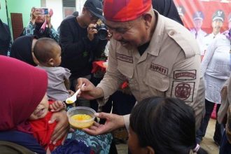 Bupati Kutai Kartanegara, Edi Damansyah saat memberikan makanan tambahan bergizi untuk balita usai meresmikan Posyandu Mawar Desa Perian.