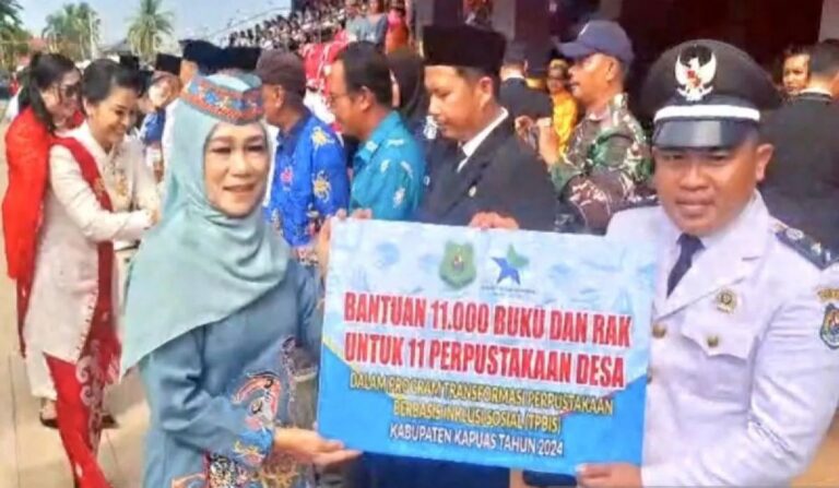 Penjabat Ketua TP PKK Kabupaten Kapuas Hj Lisdayanti, menyerahkan bantuan 11 ribu buku beserta rak secara simbolis kepada Kepala Desa Pulau Telo.