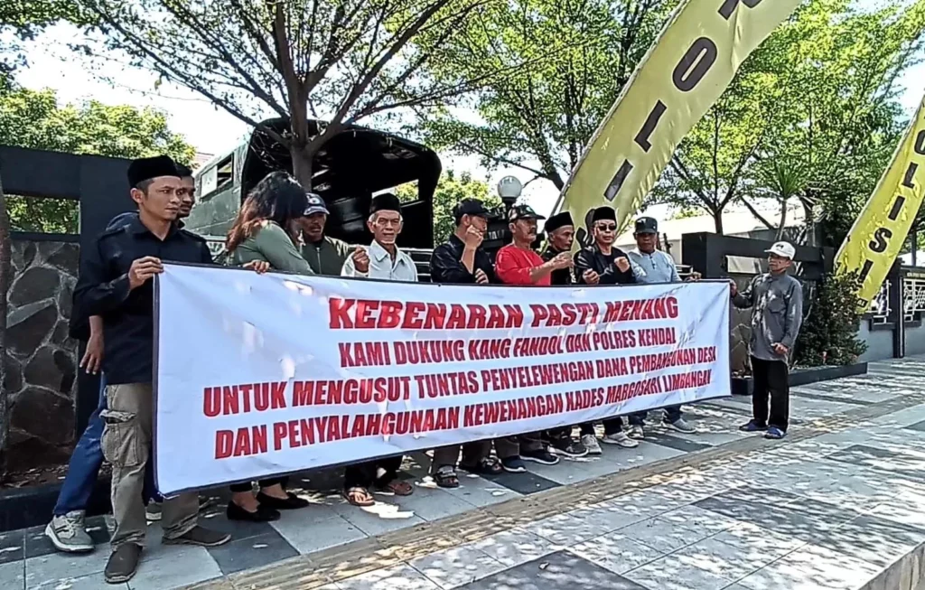 Warga membentangkan spanduk di depan Mapolres Kendal terkait penanganan kasus penyelewengan dana Desa Margosari, Limbangan. Sumber : Devi Khofiatur Rizqi/ JAWA POS RADAR SEMARANG