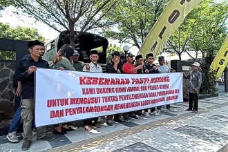 Warga membentangkan spanduk di depan Mapolres Kendal terkait penanganan kasus penyelewengan dana Desa Margosari, Limbangan. Sumber : Devi Khofiatur Rizqi/ JAWA POS RADAR SEMARANG
