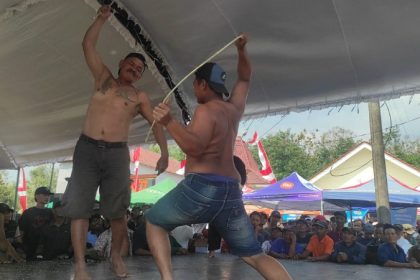 Peserta Ojung saat saling cambuk di pementasan tradisi minta hujan di depan Balai Desa Mundusewu, Kecamatan Bareng, Kabupaten Jombang Jawa Timur. Sumber : Gono Dwi Santoso/Suara Indonesia