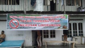 Aksi warga Desa Kalukku Barat dan Beru-Beru dengan membentangkan flayer penolakan terhadap tambang. Sumber: sulbar.tribunnews.com.