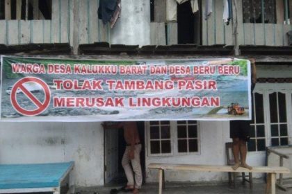 Aksi warga Desa Kalukku Barat dan Beru-Beru dengan membentangkan flayer penolakan terhadap tambang. Sumber: sulbar.tribunnews.com.