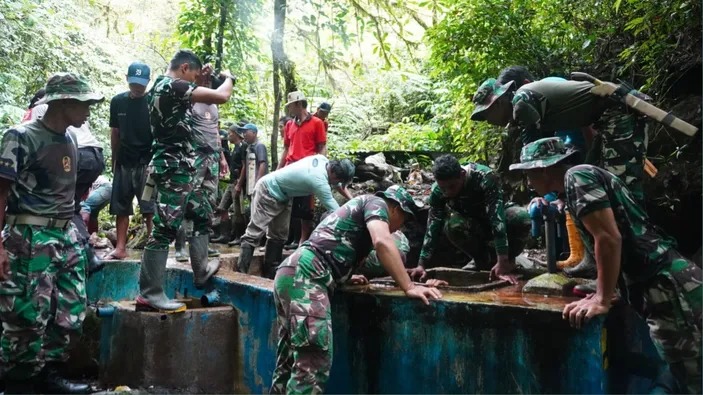 Warga Desa Poopo bersama TNI gotong Royong membersihkan bak penampungan air bersih. Sumber: journaltelegraf.pikiran-rakyat.com.