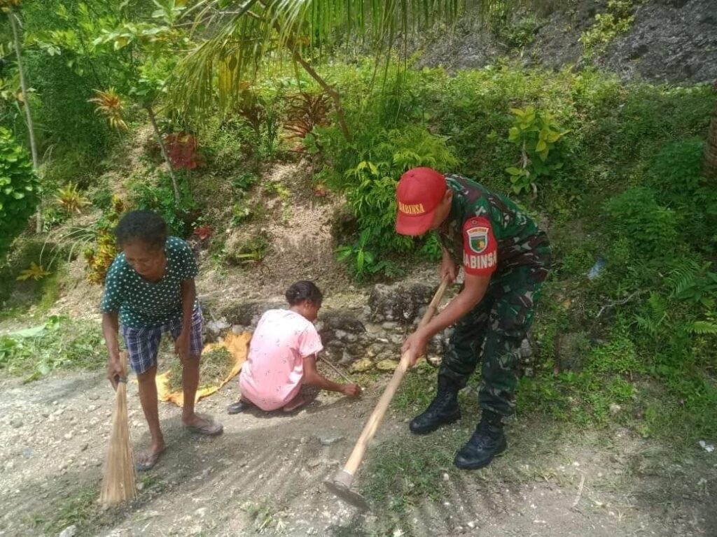 Babinsa dan warga saat pembersihan halaman rumah warga kampung Sarawandori. Sumber : Tribun-Papua.com