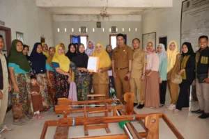 Kepala Disperin NTB, Nuryanti menyerahkan bantuan alat tenun gedogan kepada perajin di Desa Semoyang, Lombok Tengah. Sumber foto : SuaraNTB