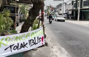 Baliho yang dipasang warga sebagai bentuk protes terkait pembangunan tempat hiburan malam di tanah kas desa Kronggahan. Sumber : Delima Purnamasari/Radar Jogja.